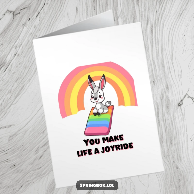Funny Free Printable Thank You Card: a springbok happily sliding down a rainbow chute, conveying cheerful gratitude.