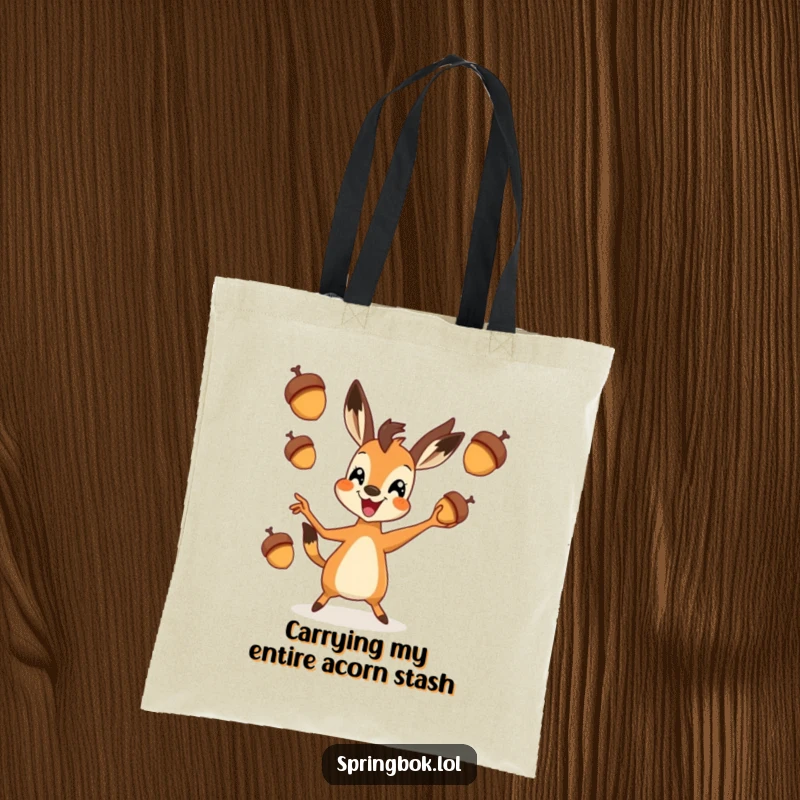 Funny springbok tote bag featuring a springbok in mid-air, exuberantly juggling three small acorns, ready for any adventure.